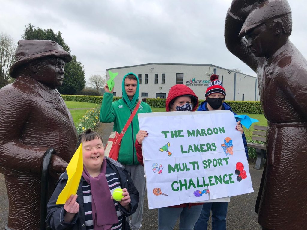 Four people hold up a sign that says Maroon Lakers Multi Sport Challenge